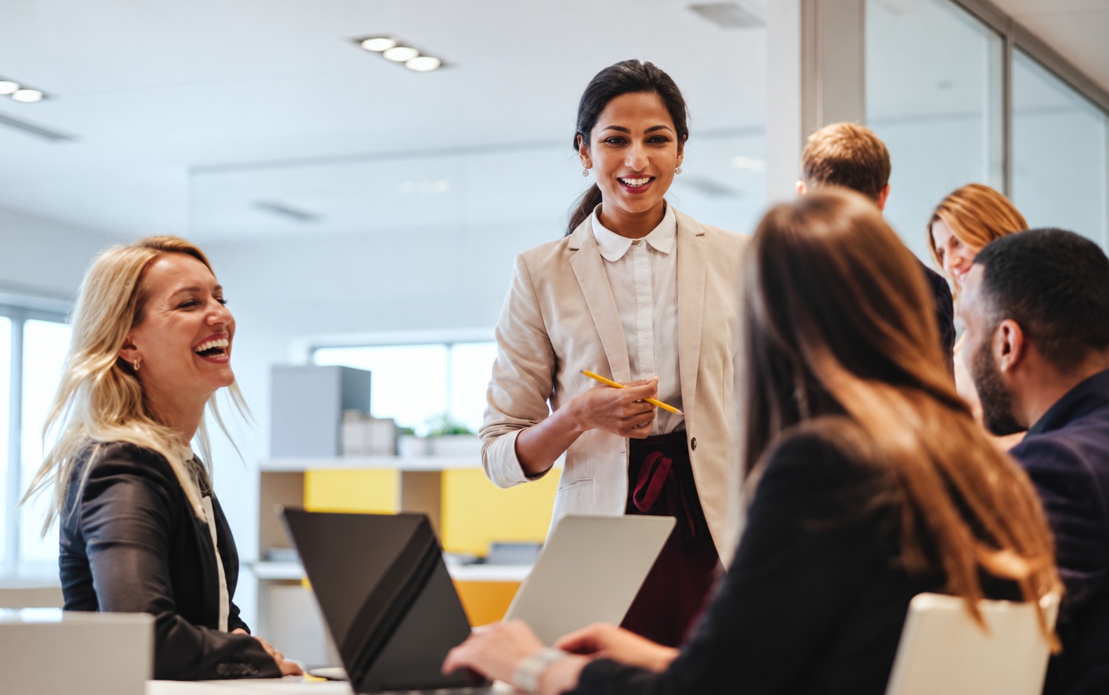 A woman presenting to her team in a bright office